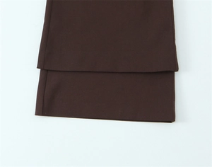 Detail einer kaffeebraunen Hose mit doppellagigem Saum und feiner Stoffstruktur