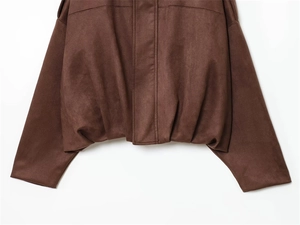 Detailed close-up of dark brown suede jacket showing fine fabric texture and hem stitching