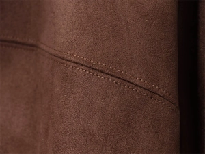 Macro shot of dark brown suede fabric with precision double-stitching details