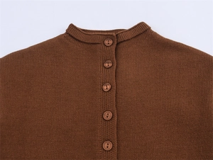 Détail de l'encolure ronde côtelée et des boutons marron sur le cardigan en maille