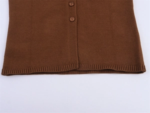 Détail du haut en tricot marron avec ourlet côtelé et boutons ronds assortis
