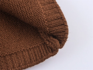 Gros plan d'un bonnet en maille marron foncé montrant les détails et la texture douce