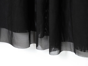 Détail de l'ourlet de la robe montrant les couches de tulle noir semi-transparent