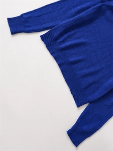Detailed view of royal blue knit sweater showing fine texture and ribbed cuffs