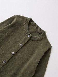 Détail macro du cardigan en laine mélangée vert olive avec col rond et boutons gris élégants