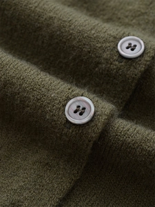 Gros plan sur le gilet en laine vert olive avec boutons gris nacrés de haute qualité