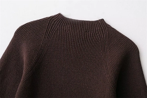 Close-up of dark brown ribbed knit sweater featuring a crew neck and raglan sleeve design