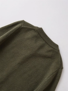 Détail de cardigan en laine vert olive avec col rond côtelé et texture de maille fine