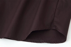 Detail of deep brown poplin shirt showing high-quality stitching and fabric texture