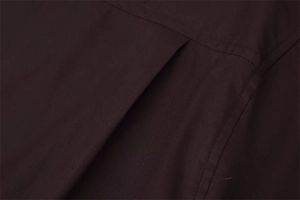 Detail view of back box pleat and yoke stitching on a dark brown poplin shirt