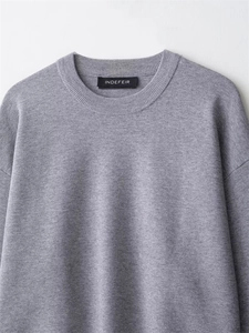 Nahaufnahme des hellgrauen Rippbündchens und der Strickstruktur dieses Casual-Pullovers