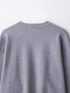 Detailaufnahme des grauen Rippstrick-Pullovers mit Fokus auf den runden Halsausschnitt