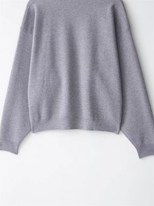 Detail von Rippbündchen und Saum an einem grauen Strickpullover mit feiner Textur