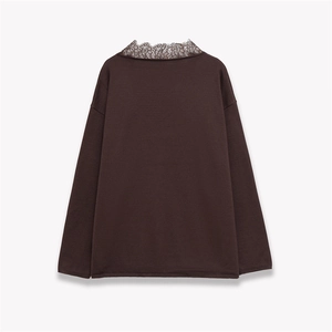 Detail of the brown polyester blend knit top featuring a delicate lace-trimmed neckline