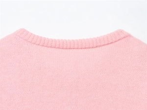 Dettaglio della trama in maglia rosa morbida e delle cuciture fini sulla scollatura