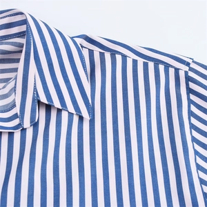 Close-up of the collar and shoulder seams on a blue striped cotton poplin shirt