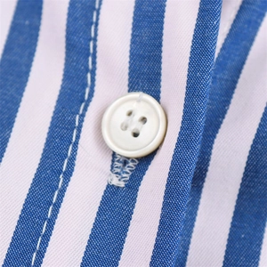 Macro view of white four-hole button and clean stitching on blue striped poplin shirt