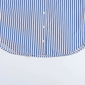 Detail of blue striped poplin shirt featuring curved hem and white buttons