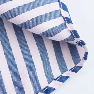 Close-up of blue and white striped cotton poplin fabric with high-quality stitching details