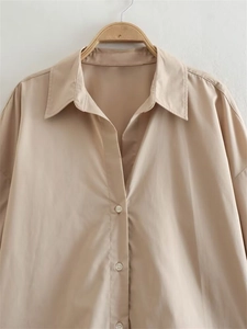 Detailed close-up of a khaki striped poplin shirt with a spread collar and buttons