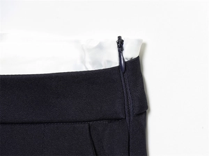 Dettaglio del tessuto twill blu navy con fodera in raso bianco e cerniera invisibile abbinata