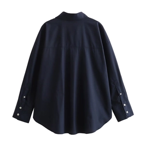 Detail view of navy blue poplin shirt back with box pleat and white buttoned cuffs