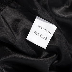 Detail van 100% polyester stoftextuur en waslabel op een zwarte jas voor vrouwen