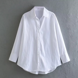 Detailed view of white poplin shirt featuring classic collar and button-down cuffs