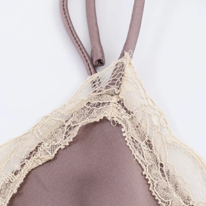 Gros plan sur la bordure en dentelle délicate et le tissu satiné de la robe midi prune