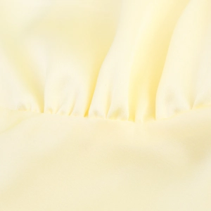 Detail von hellgelbem Seidensatinstoff mit feinen gerüschten Faltenstrukturen