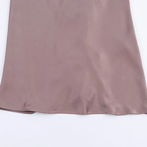 Vue macro détaillée de l'ourlet de la robe en satin taupe avec couture fine