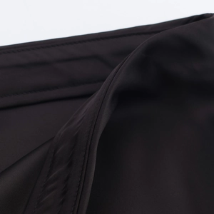 Detailed macro view of the double stitching and smooth texture on black satin lace midi skirt