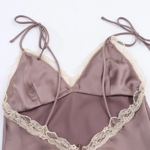 Détail d'un caraco en satin de soie avec dentelle délicate et bretelles à nœuds