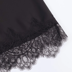 Detailed close-up of the black satin midi skirt featuring elegant eyelash lace hem trim