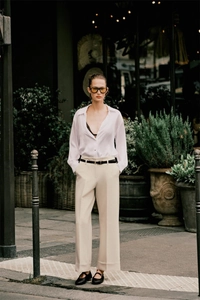 Completo urbano chic con camicia bianca a maniche lunghe e pantaloni beige larghi