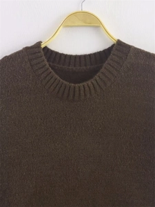 Close-up of the ribbed crewneck and soft brushed texture on this brown knit sweater