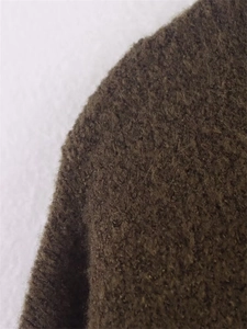 Macro view of olive green wool texture on a comfortable vintage style knitted sweater