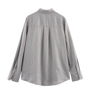 Detail of the back view of a gray linen shirt featuring yoke seams and box pleat design