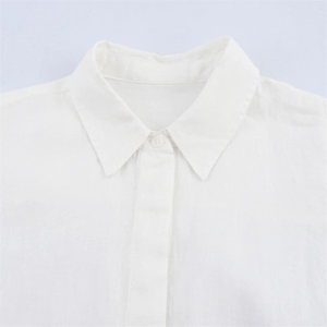 Close-up of classic collar and button detail on white linen shirt with natural texture