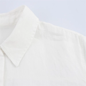 Close-up of the white linen shirt collar showing texture and fine stitching detail
