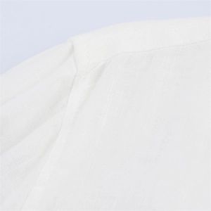 Close-up of shoulder seam stitching on lightweight white linen pants and shirt