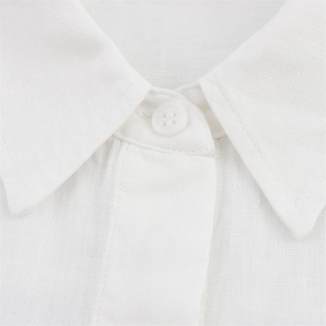 Close-up detail of white linen shirt collar showing fabric texture and simple resin button