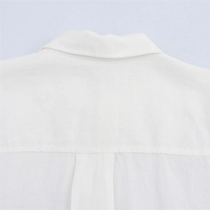 Detailed macro shot of white linen shirt yoke with reinforced stitching and fiber texture