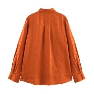 Back view of a long-sleeved orange linen shirt featuring a classic box pleat detail