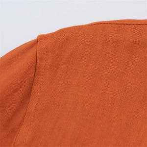 Detail view of the flat seam shoulder stitching on an orange linen blend shirt