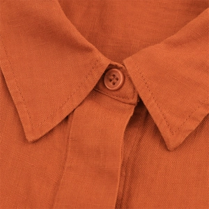 Detail of linen shirt collar and resin button showing natural fabric texture and stitching