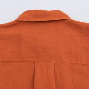 Detailed view of the burnt orange linen shirt featuring a back yoke and classic box pleat
