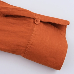 Close-up of orange linen shirt cuff featuring natural fiber texture and tonal resin buttons
