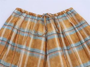 Close-up of checkered linen pants featuring drawstring waist and elastic band detail