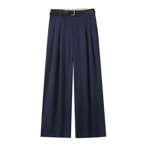 Dettaglio dei pantaloni a gamba larga blu navy con pieghe eleganti e cintura nera in vita